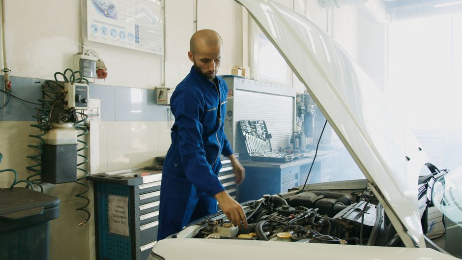 Technician using a diagnostic scan tool on an engine